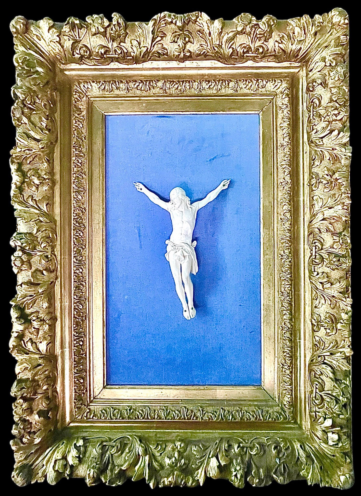  Cristo in avorio con cornice in legno intagliato e dorato a motivi vegetali.