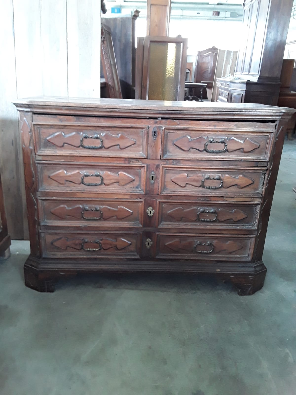 Lombardische Nussbaumkommode aus der Zeit mit originaler Patina. Die erste Schublade ist eine Klappschublade mit einer wunderschönen Schubladenkommode im Inneren. Das Paneel an der Seite hat eine Form, die Füllungen an allen Schubladen haben, Epoche 1600 