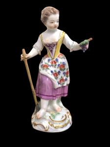 Porcelain figurine, figure of a peasant woman with a stick and bunch of grapes. Meissen.