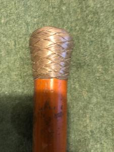 Bastone con pomolo in argento intrecciato e canna in malacca.