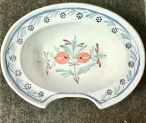 Piatto ovale da barba in maiolica decorato a motivi floreali .Francia.