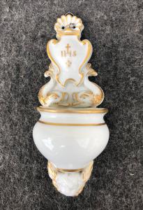 Weihwasserbecken aus weißem und goldenem Porzellan mit Tritonen, Putte und dem Bernhardinischen Symbol. Italien.