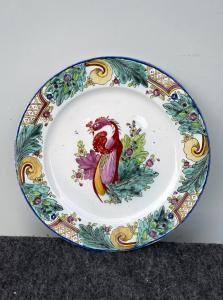 Piatto in maiolica con decoro stile orientale con foglie di tabacco e motivi rocaille sulla tesa e uccello nel cavetto.Manifattura di Felice Clerici.Milano.