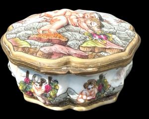 Scatola in porcellana con corpo lobato decorata con cherubini. Ginori-Capodimonte.