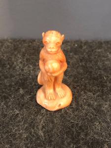 Small coral sculpture depicting a monkey holding a globe. Sciacca, Sicily.