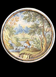 Maiolica roundel depicting a hunter shooting game against a rural backdrop with architecture. Castelli d'Abruzzo.