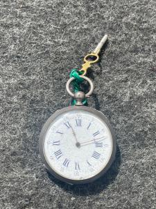Silberne Taschenuhr mit römischen Ziffern.