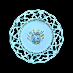 Piatto in maiolica con tesa lobata e traforata.Decoro a motivi geometrici stilizzati e stemma nobiliare al centro.Manifattura di Angelo del Vecchio .Napoli(op.1753-1764).