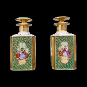 Pair of porcelain perfume bottles with female figures and floral and gold decorations. France.