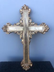 Croce in legno intagliato e dorato con motivi vegetali stilizzati.