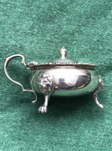 Silver sauce boat on three feet with masks and knurling. London 1933.