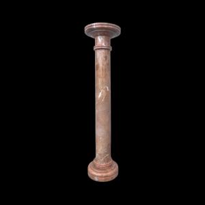 Two-part pink marble column with veins. Shaped base and capital.