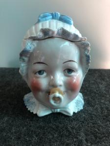 Porcelain tobacco box depicting an infant's head. France.