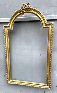 Gilded mirror with shaped crest.