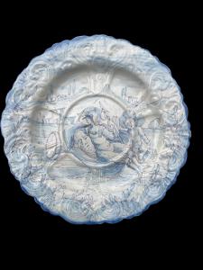 Majolica plate decorated in turquoise monochrome with characters on a rural background. Savona
