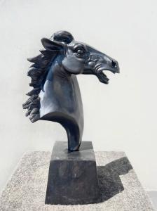 Scultura in bronzo con base raffigurante testa di cavallo.