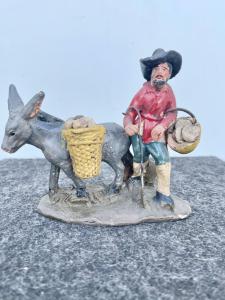 Krippenfigur aus Terrakotta, die eine populäre Figur darstellt, einen Brotverkäufer mit Esel. Umfeld von Pietro Aldrovandi. Bologna.