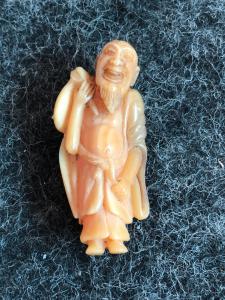 Netsuke aus Horn, das eine Figur darstellt. Japan.