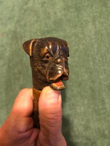 Glove holder stick with a wooden knob depicting a dog's head. Rosewood shaft.