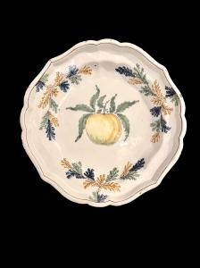 Faience plate with vegetable racemes on the rim and fruit in the center. Pavia.
