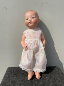 Bambola bebe'caractère con testa in bisquit, occhi mobili e corpo in cartapesta.Firma Armand Marseille.Germania.