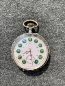 Taschenuhr aus Silber und Emaille mit floralen und geometrischen Verzierungen.